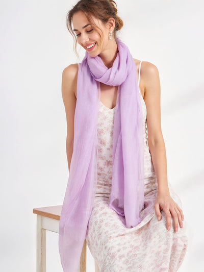 Woman wearing a light purple scarf on a white background