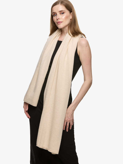 Woman wearing a beige cashmere wrap on a white background