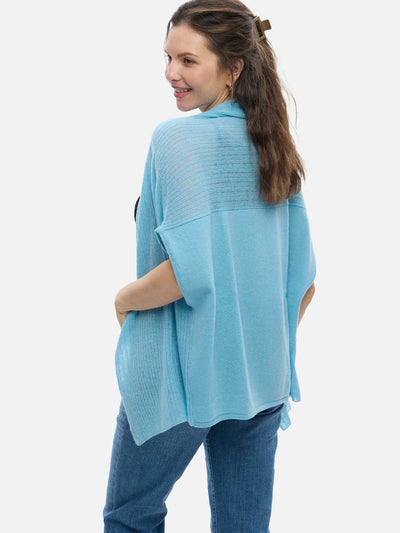 Woman wearing a light blue cashmere vest over a blue outfit on a white background