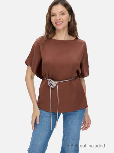 Woman wearing a brown silk top with a belt, on a white background