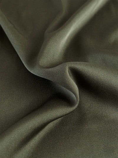 Close-up of dark green silk top with folds