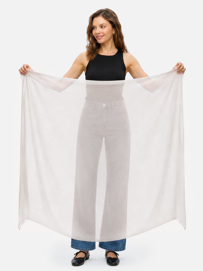 A woman holding the Ivory Featherlight Square Cashmere Scarf.