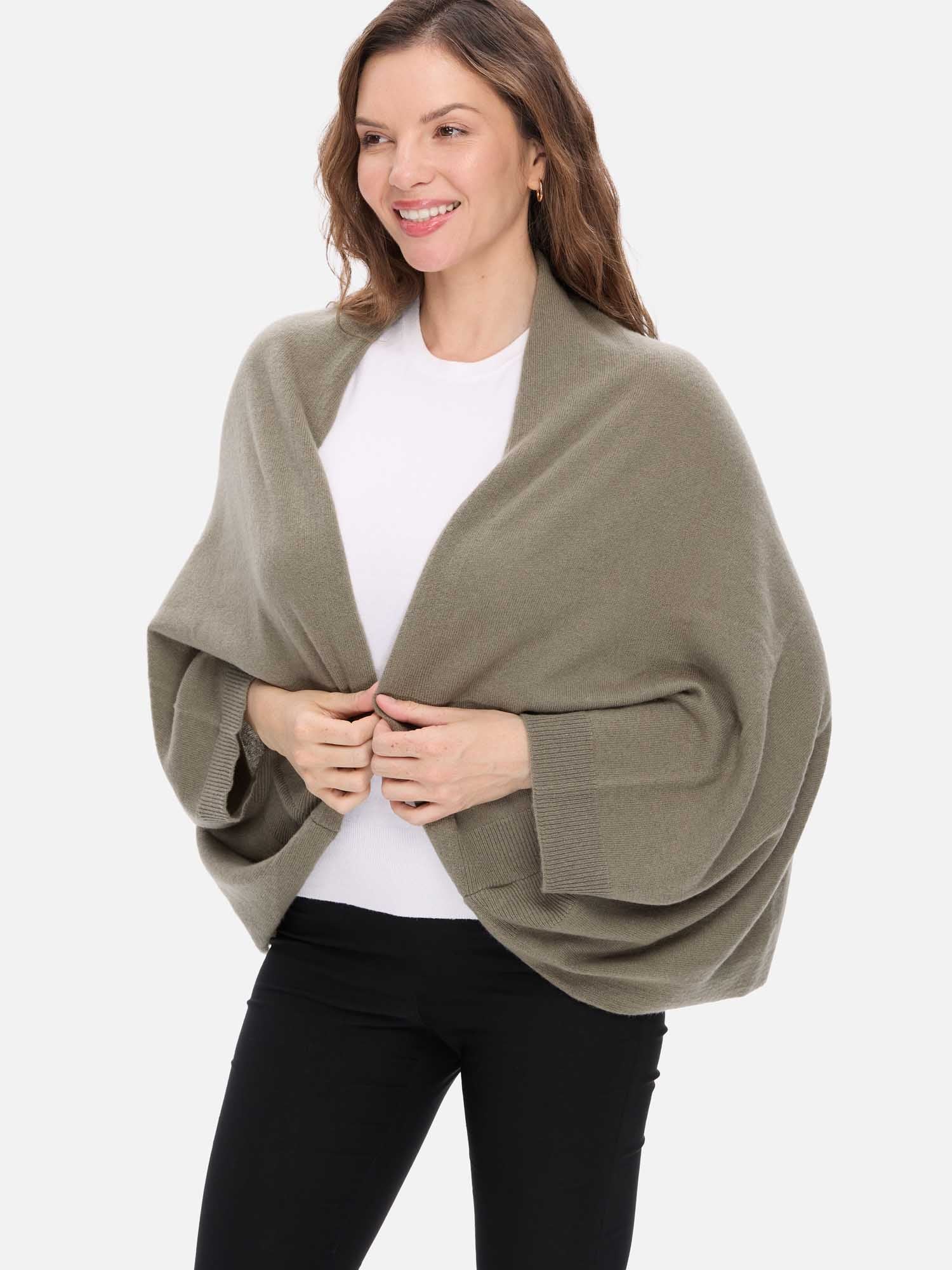 Woman wearing a green cashmere wrap over a white shirt on a white background