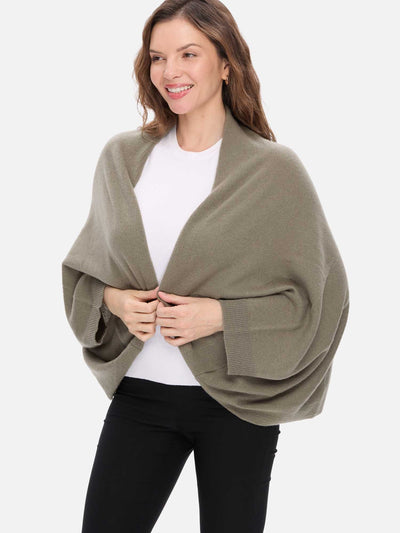 Woman wearing a green cashmere wrap over a white shirt on a white background