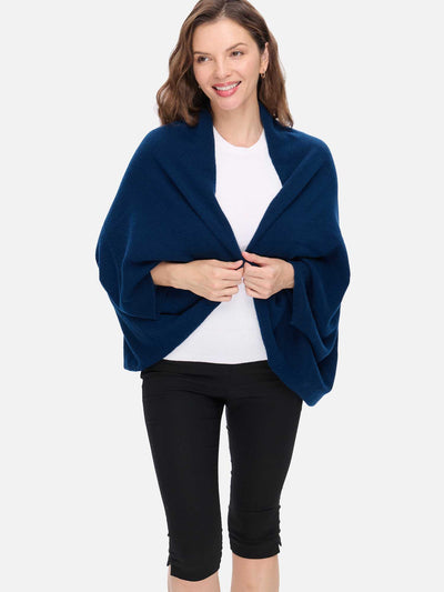 Woman wearing a blue cashmere wrap over a white shirt and black pants on a white background