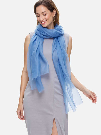 Woman wearing a light blue scarf on a plain background