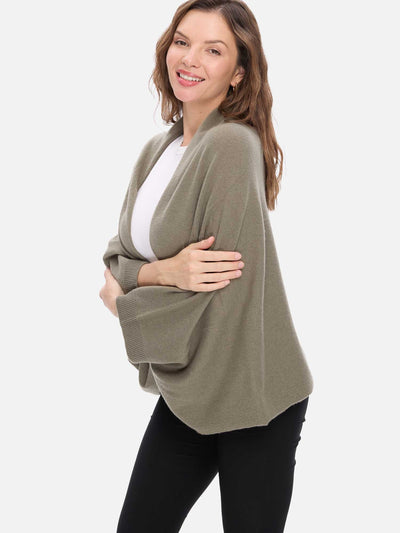 Woman wearing a green cashmere wrap over a white shirt on a white background