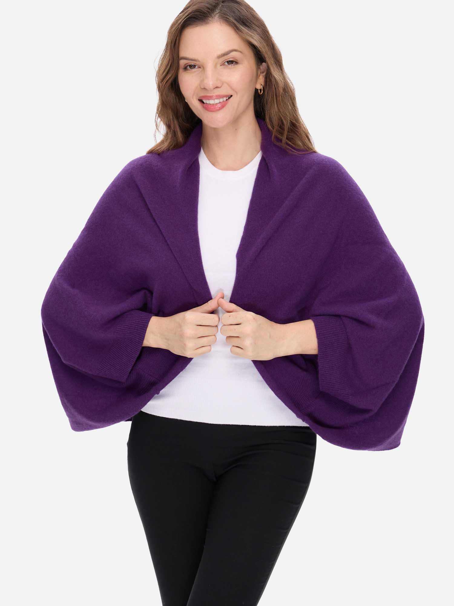 Woman wearing a purple cashmere wrap over a white top and black pants on a white background