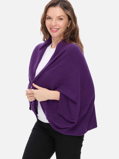 Woman wearing a purple cashmere wrap over a white top on a white background