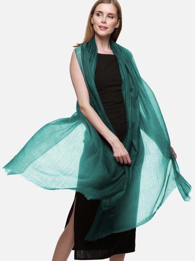 Woman wearing a teal cashmere scarf on a white background