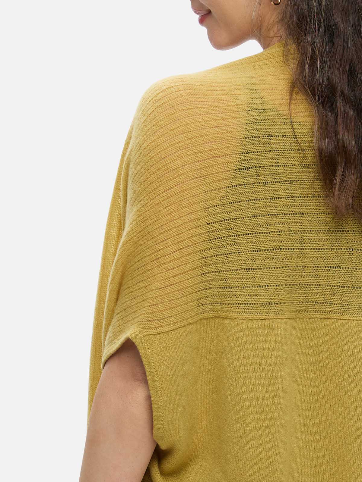 Yellow knit cashmere vest worn by a person on a white background