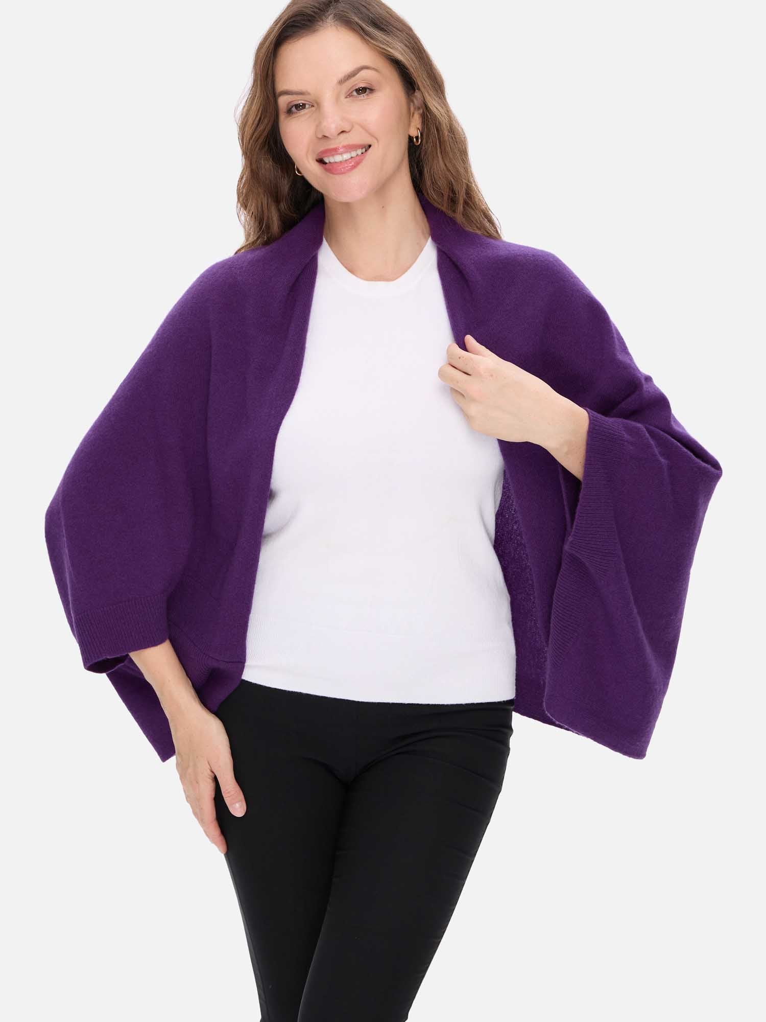 Woman wearing a purple cashmere wrap over a white shirt and black pants on a white background