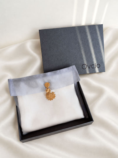 An open black box with a pouch that contained the Ovcio featherlight cashmere scarf.