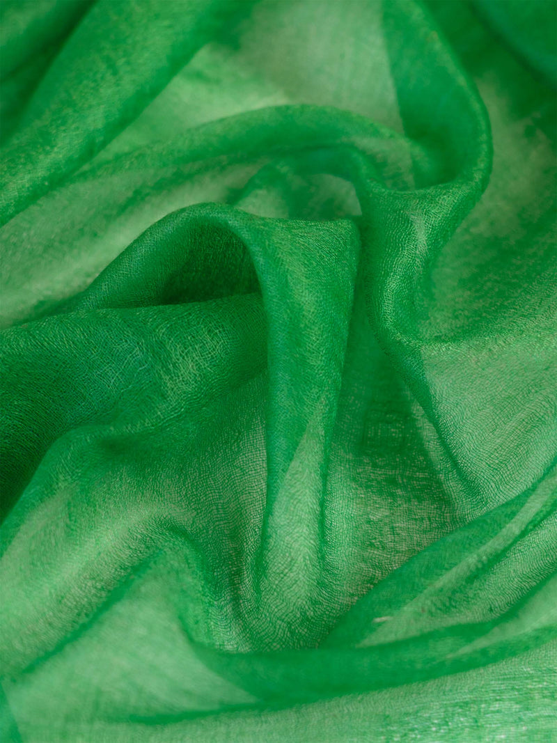 Woman wearing a green scarf and beige sweater on a white background