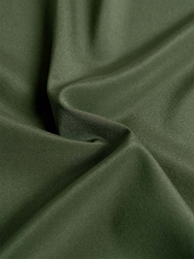 A close-up of draped olive green silk fabric with soft folds and a smooth texture.
